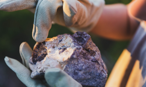 STEAM Skills - child inspecting a rock in their hands while wearing gloves