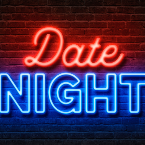 Date Night written in neon lights against a brick wall