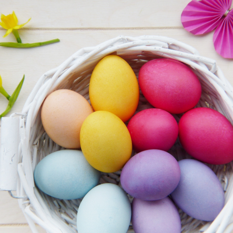 colorful easter eggs in a white basket