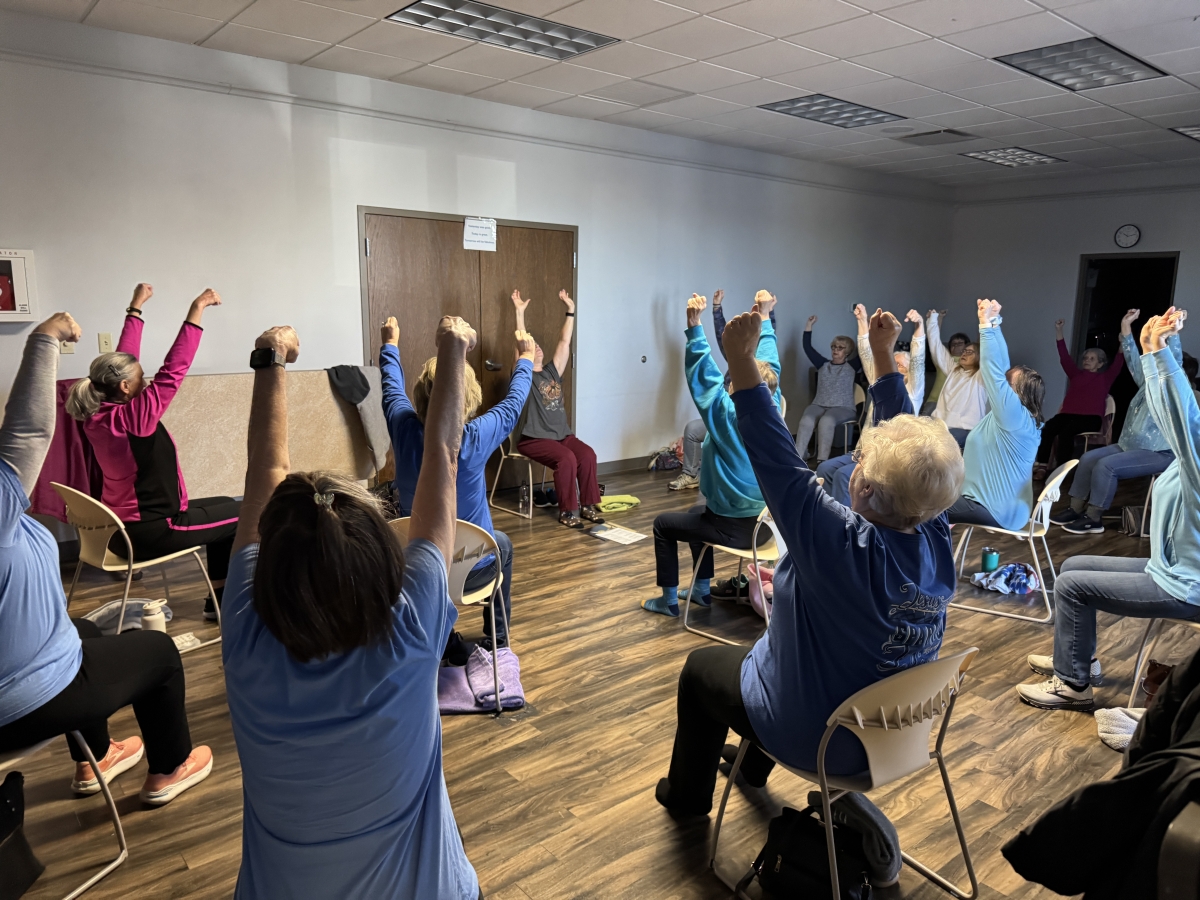 Chair Yoga in the TCPL Community Room - patrons are sitting in chairs with raised arms