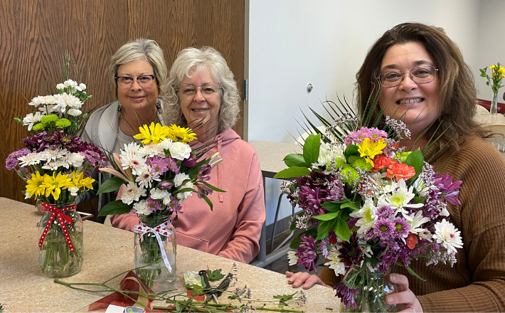 TCPL Events - Three patrons posing by bouquets.png