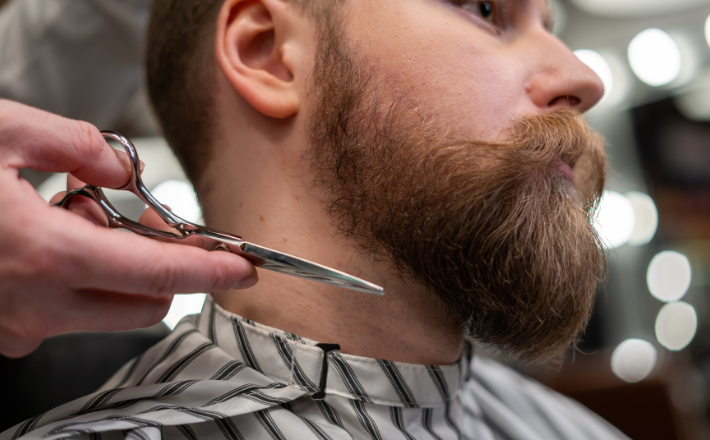 man getting his beard trimmed