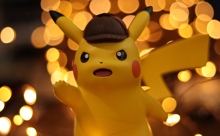 a yellow Pokemon doll with dark background and blurred white lights 