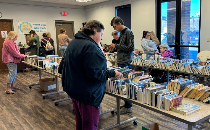 patrons browsing books in the TCPL Community Room at a book sale